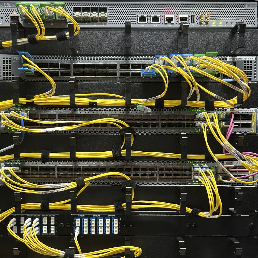 Verkabelter Server in einem Rack mit zahlreichen gelben und einigen violetten Netzwerkkabeln.